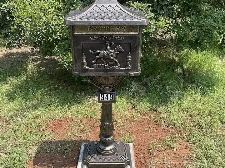 Decorative locking mailbox on a pedestal post, front view